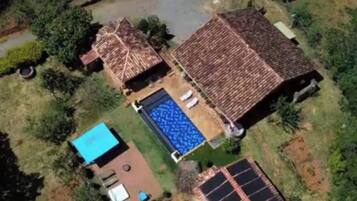 Imóvel residencial com piscina, painéis solares e quintal cercado.