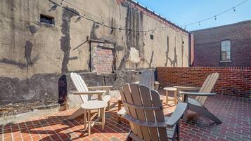 A patio with outdoor seating and a brick wall.