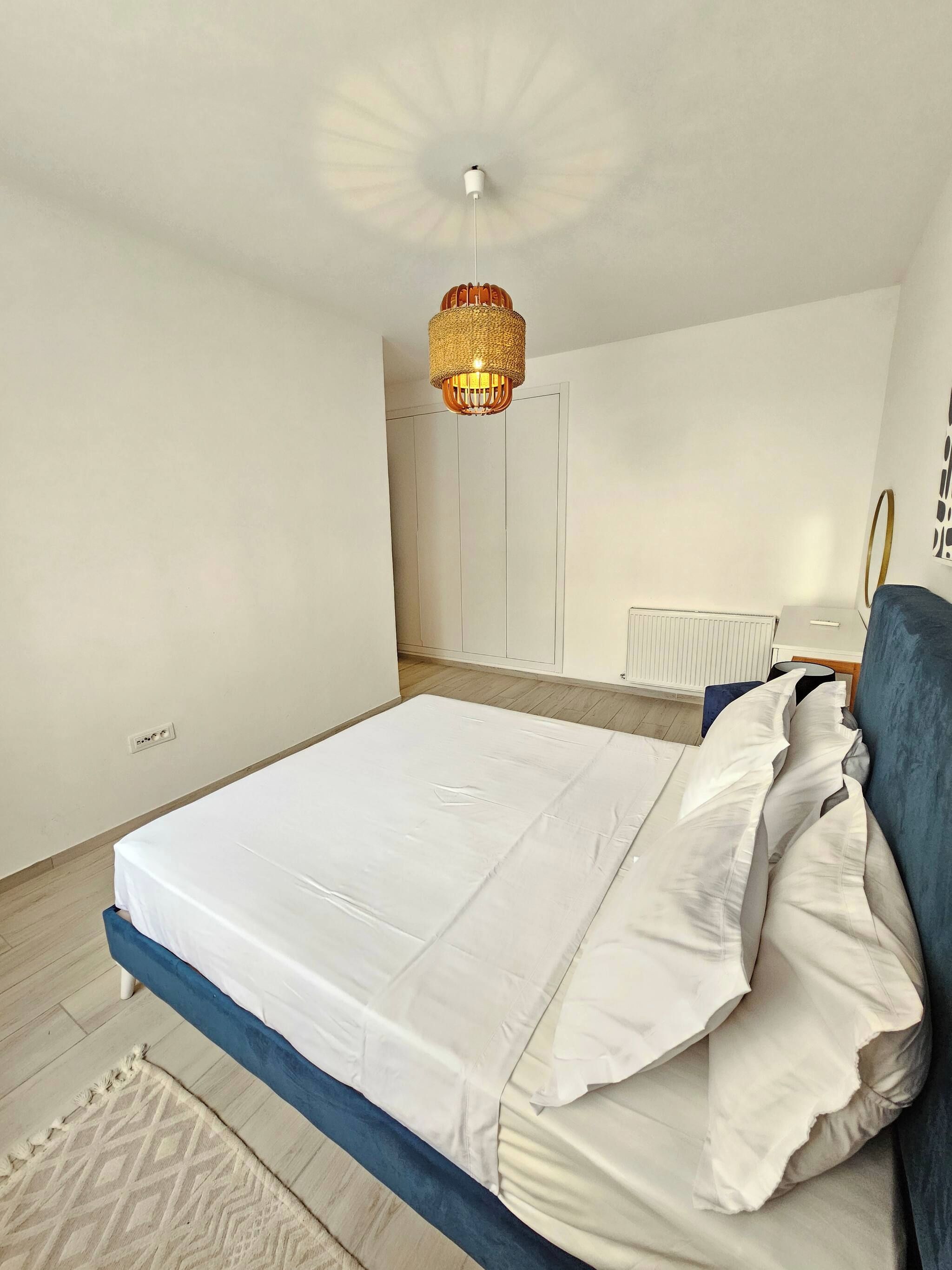 Una camera da letto con un letto, un comodino, una lampada e un lampadario.