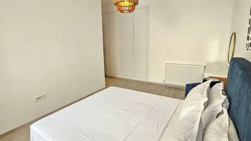 Una camera da letto con un letto, un comodino, una lampada e un lampadario.