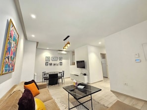 A modern living room with a sofa, coffee table, and dining area. - Contemporary Haven in the Heart of La Marsa (Marsa)