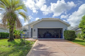 Eine Garage mit einem Fahrzeug, umgeben von Grünpflanzen und blauem Himmel.