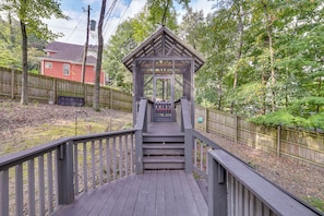 A wooden bridge leading to a gazebo with a roof, surrounded by a wooden fence and trees. - Chattanooga Home w/ Treetop Deck & Yard! (Chattanooga)