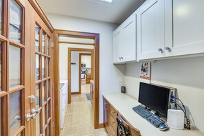 A home office with a desk, computer, and printer. There is a kitchen in the background. - Chattanooga Home w/ Treetop Deck & Yard! (Chattanooga)