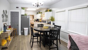Une cuisine compacte comprenant une table à manger, des chaises et un réfrigérateur.
