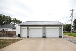 A two-car garage with a metal roof and white garage doors.