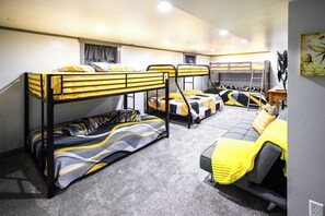 A bunk bed room with a sofa and a desk.