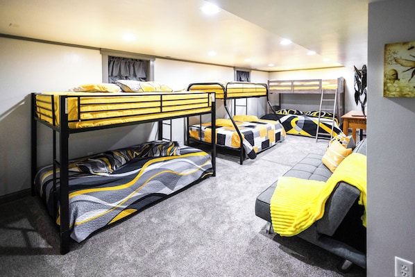 A bunk bed room with a sofa and a desk.