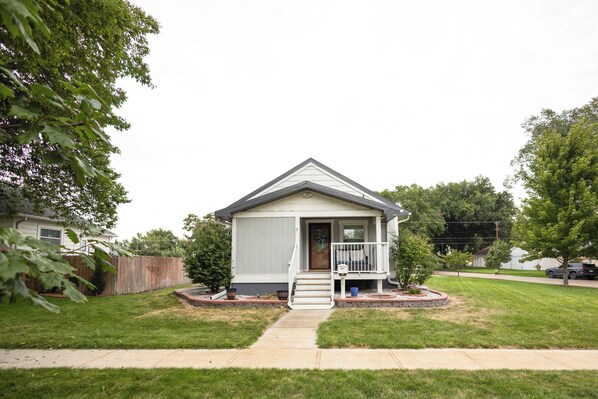 A single-story house with a front porch, a small front yard, and a visible mailbox.