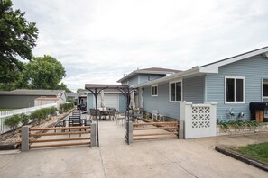 Bairro residencial com casas, portão fechado e mobiliário de exterior.