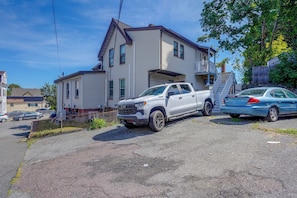 A two-story house with a driveway and parked vehicles. - Boston Basecamp: Modern Malden Apartment (Malden)