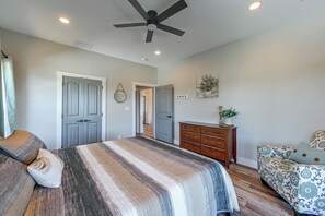 Une chambre à coucher avec un lit, une commode et un ventilateur de plafond.