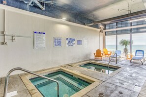 An indoor pool area with clear pool rules posted on the wall, a lifeguard on duty sign, and a view of the ocean through large windows. - Sand Dunes Resort Condo w/ Water Views! (Myrtle Beach)