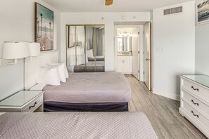 A hotel room with a bed, bedside tables, a dresser, a mirror, and a door leading to a bathroom. - Sand Dunes Resort Condo w/ Water Views! (Myrtle Beach)