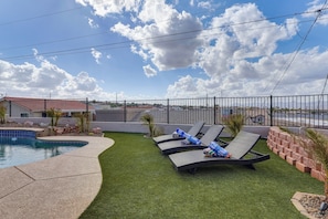 A backyard with a swimming pool, lounge chairs, and a fenced area. - Mtn Views, Hot Tub! Extended Lake Havasu Escape (Lake Havasu City)