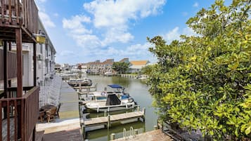 A marina with docked boats, wooden walkways, and buildings in the background.