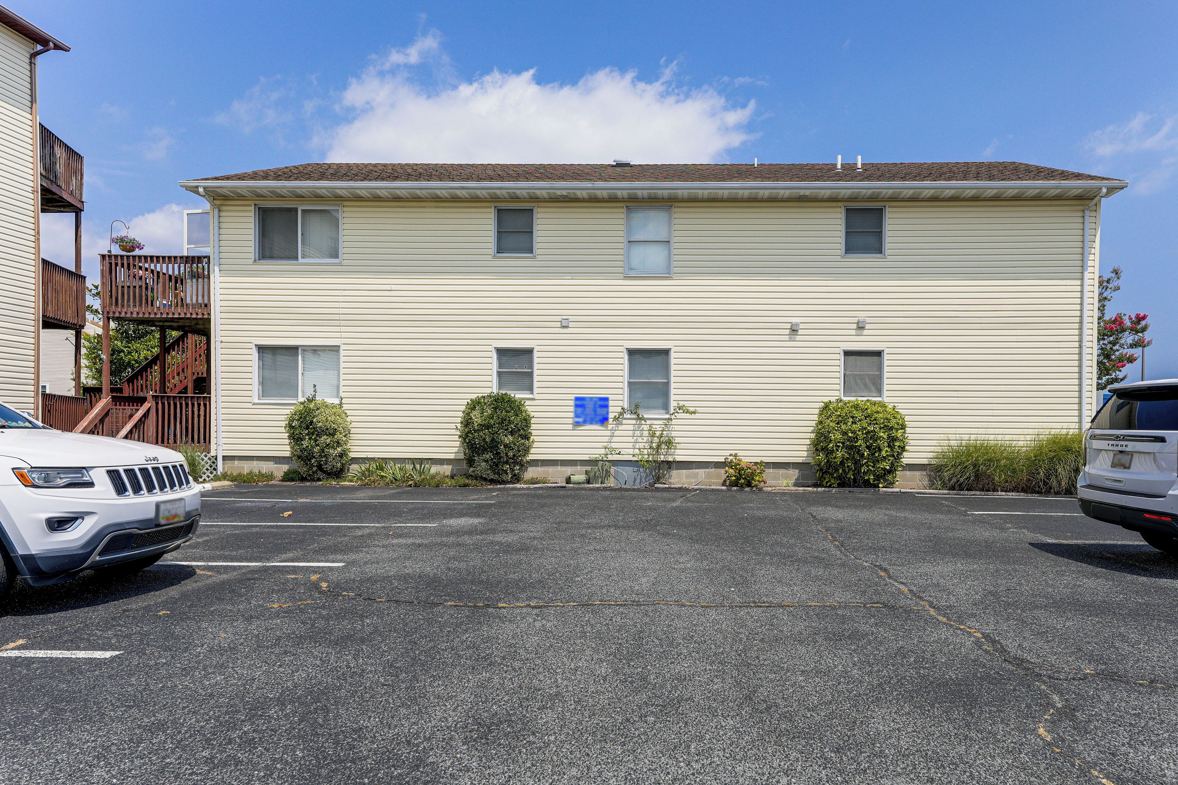 A two-story building with a parking lot in front.