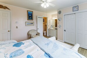 A bedroom with a bed, a chair, a bathroom, and a door. - Bayside Waterfront OC Sleeps 8 | Beach | Boardwalk (Ocean City)