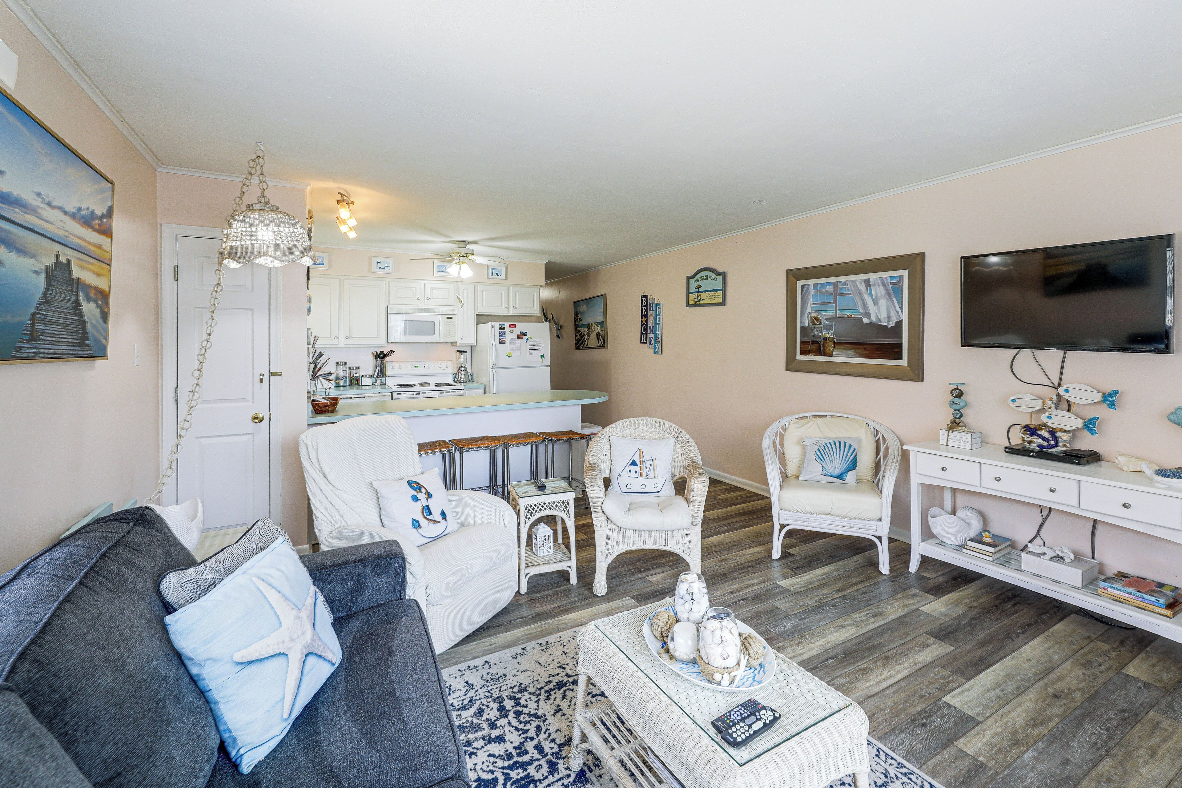 Een woonkamer met een bank, stoelen, een salontafel en een televisie.