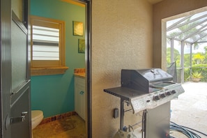 A bathroom with a toilet, a window with blinds, and a wall with textured plaster. - Private Yard w/ Fire Pit & Pool! Cape Coral Escape (Cape Coral)