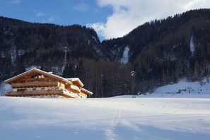 Una cabana de fusta amb diversos balcons, amb una muntanya nevada al fons.