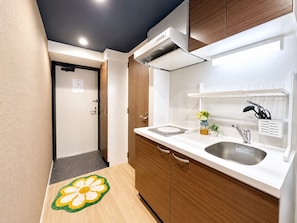 A modern kitchen with a sink, cabinets, and a countertop. - Vrbo Property (大阪市西区九条南3-19)