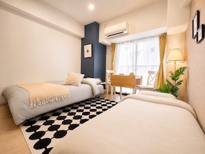 A compact hotel room with a bed, a desk, and a chair. - Vrbo Property (大阪市西区九条南3-19)