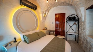 A bedroom with a bed, bedside table, lamp, and a wardrobe. - HOTEL ESTARA (Şanlıurfa)