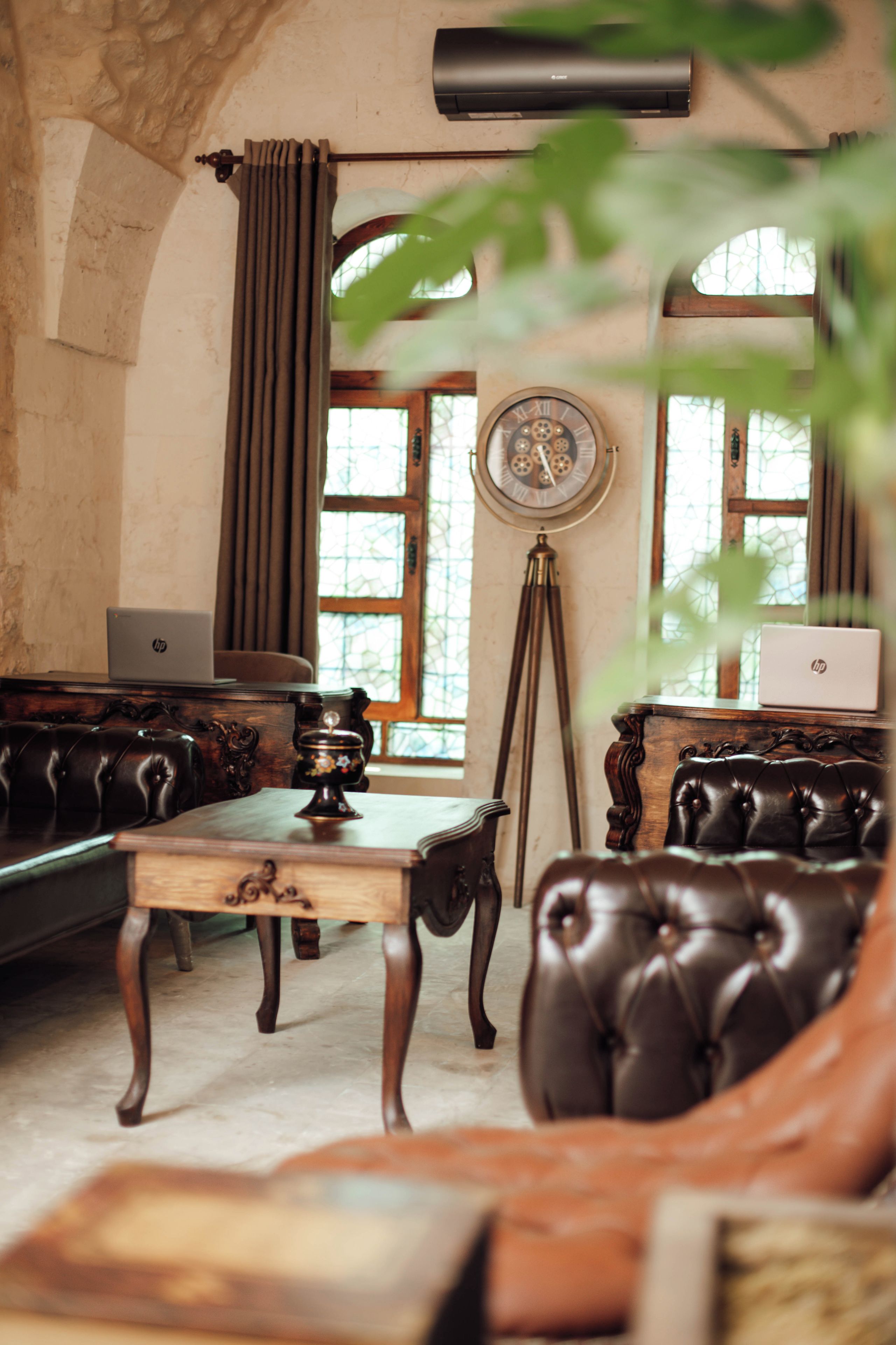Ein Zimmer im Vintage-Stil mit einer Ledersofa, einem Holztisch und einer klassischen Wanduhr.