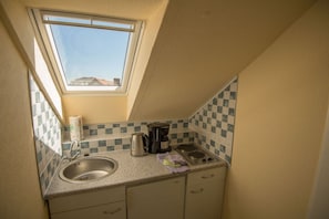 A small kitchen with a window, a sink, a kettle, and a coffee maker. - Beach House Atlantic 32 (Norderney)