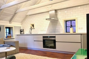 Eine moderne Küche mit weißen Schränken, einem Einbauofen und einem Fenster mit Blick.