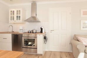 Een moderne keuken met roestvrijstalen apparatuur, een houten werkblad en een witte kast.