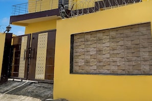 A yellow building with a large window and a decorative door. - Super Hotel O Samne Ghat (Varanasi)