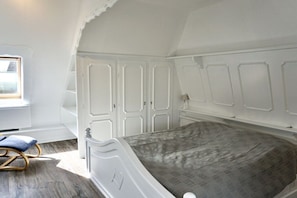 Un dormitorio con una cama individual, una ventana y un armario.