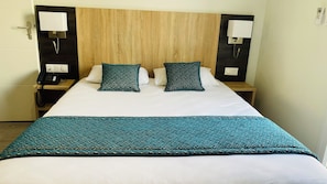A hotel room with a bed, two bedside tables, a telephone, and a wall-mounted light fixture. - Appart'hôtel Martinez (Grenay)