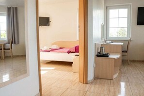 A bedroom with a bed, a desk, a chair, a TV, and a window. - One-bedroom guesthouse in Poland (Grzybowo \/ Kolberg)