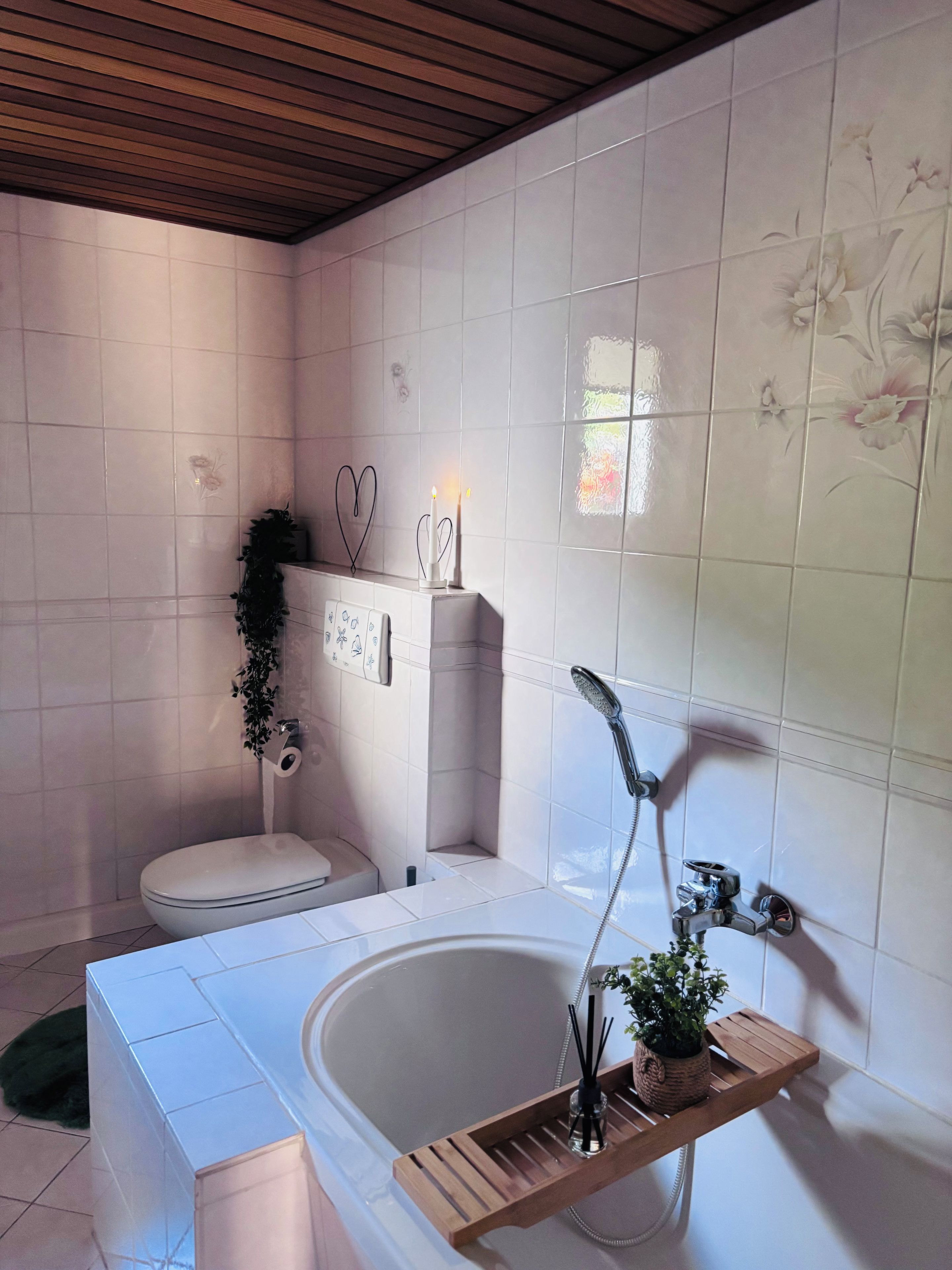 Ein Badezimmer mit Badewanne, Toilette, Dusche und einem fest installierten Toilettenpapierhalter.