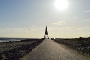 A pathway leading to a lighthouse structure on a beach. - Holiday apartment Chalet Cuxhaven "Weser" (Cuxhaven)