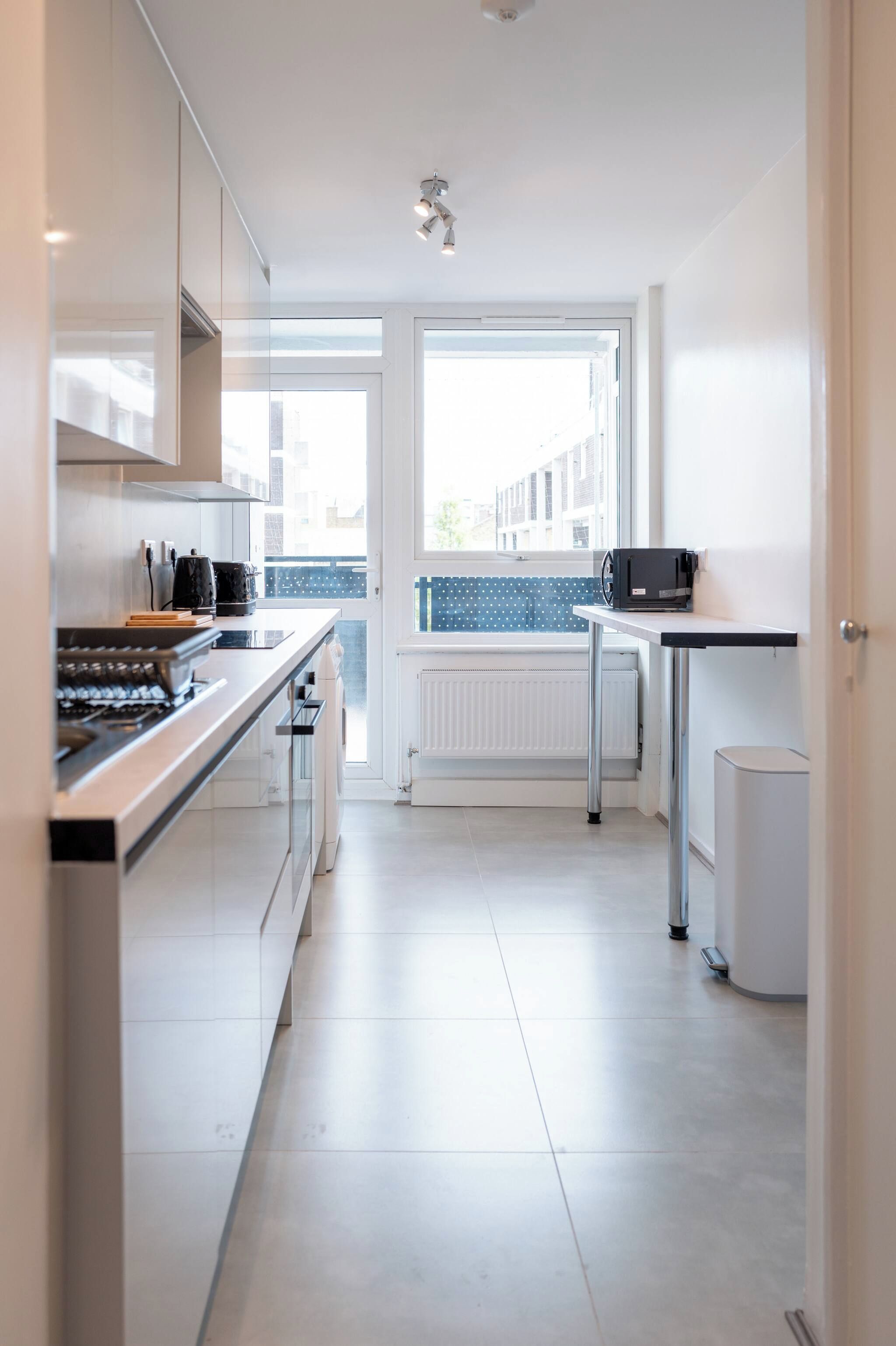 A modern kitchen with a built-in oven, a coffee machine, and a microwave on a countertop.