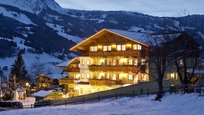 A multi-story hotel with a sloped roof, located in a snowy mountainous area. - Apartment in Dorfgastein with swimming pool (Dorfgastein)