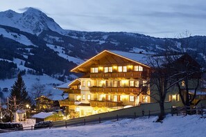 A multi-story hotel with a sloped roof, located in a snowy mountainous area. - Apartment in Dorfgastein with swimming pool (Dorfgastein)
