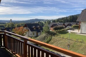 Ein Wohngebiet mit Häusern, einem grasbewachsenen Hügel und blauem Himmel.