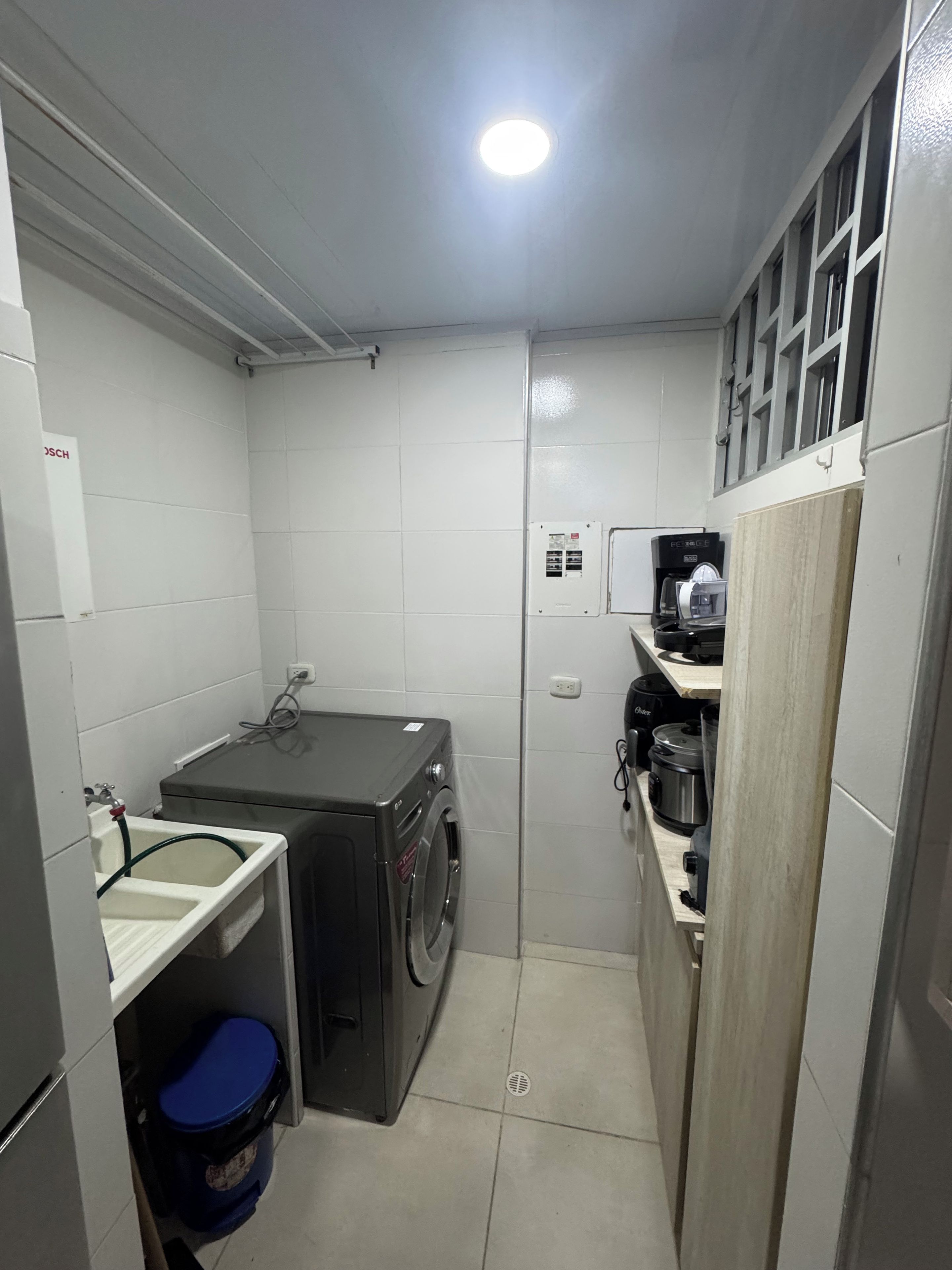A compact kitchen with a washing machine, a sink, and a stove.