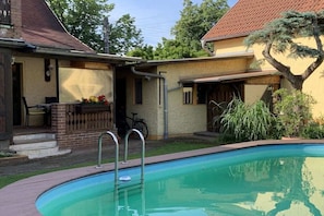 Ein Wohnhaus mit Schwimmbad, überdachter Terrasse und einem Fahrrad.
