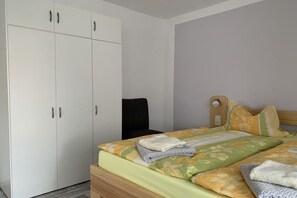 Ein Schlafzimmer mit Bett, Kleiderschrank und Stuhl.