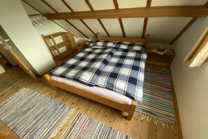A room with a wooden bed, a striped rug, and a wooden bench. - Bredene Fisherman's House (Bredene)