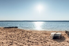 A beach with footprints leading to a covered area with a grill. - Holiday home in Löbnitz with swimming pool (Löbnitz)