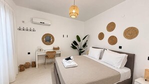 Ein modernes Schlafzimmer mit Bett, Schreibtisch und einer Pendelleuchte.