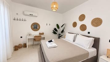 Un dormitorio moderno con cama, escritorio y lámpara colgante.