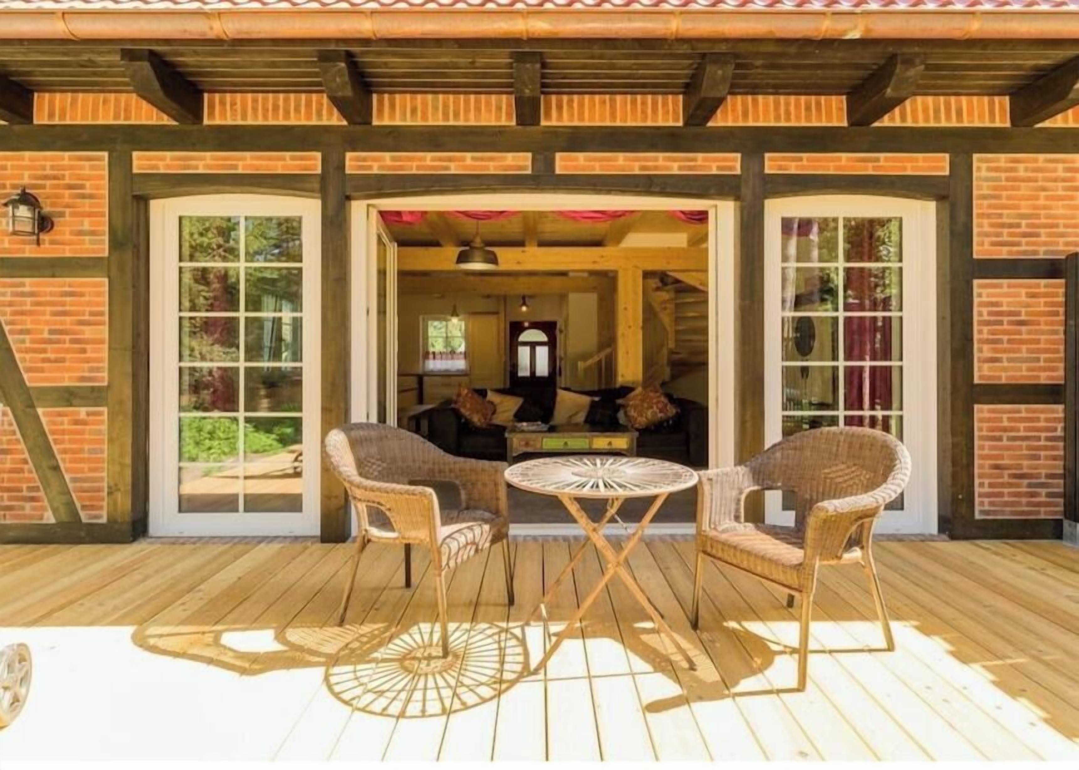 An outdoor patio with wicker furniture and a wooden deck.